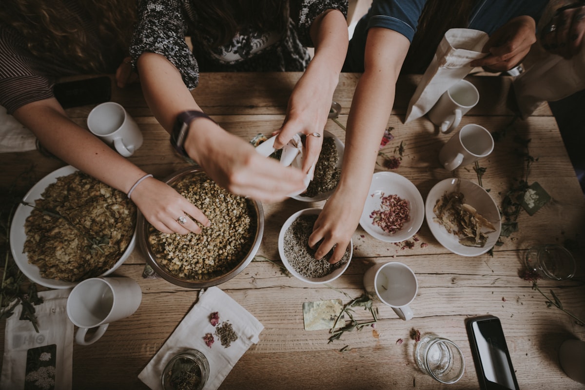 Hands preparing food together on a wooden table