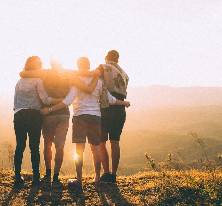 A group of friends standing together at sunset